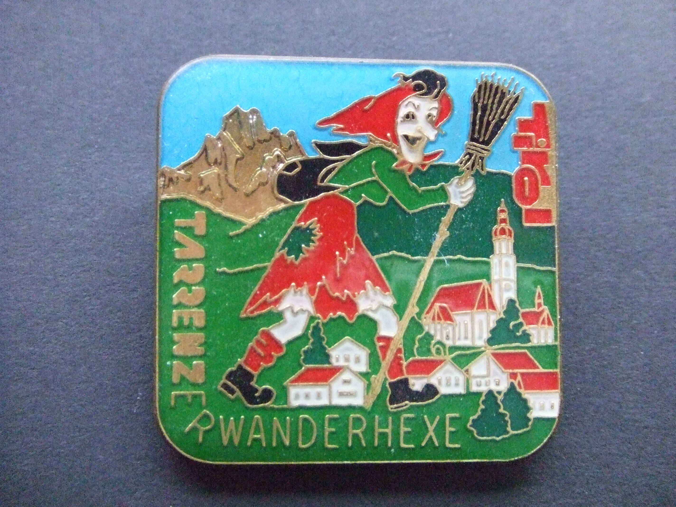 Tirol Heks met bezem wandelend door de bergen